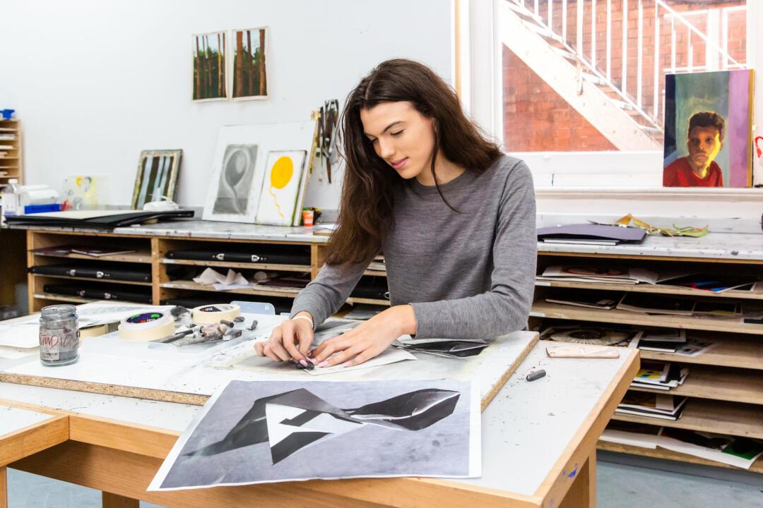 A girl working on her artwork at a table