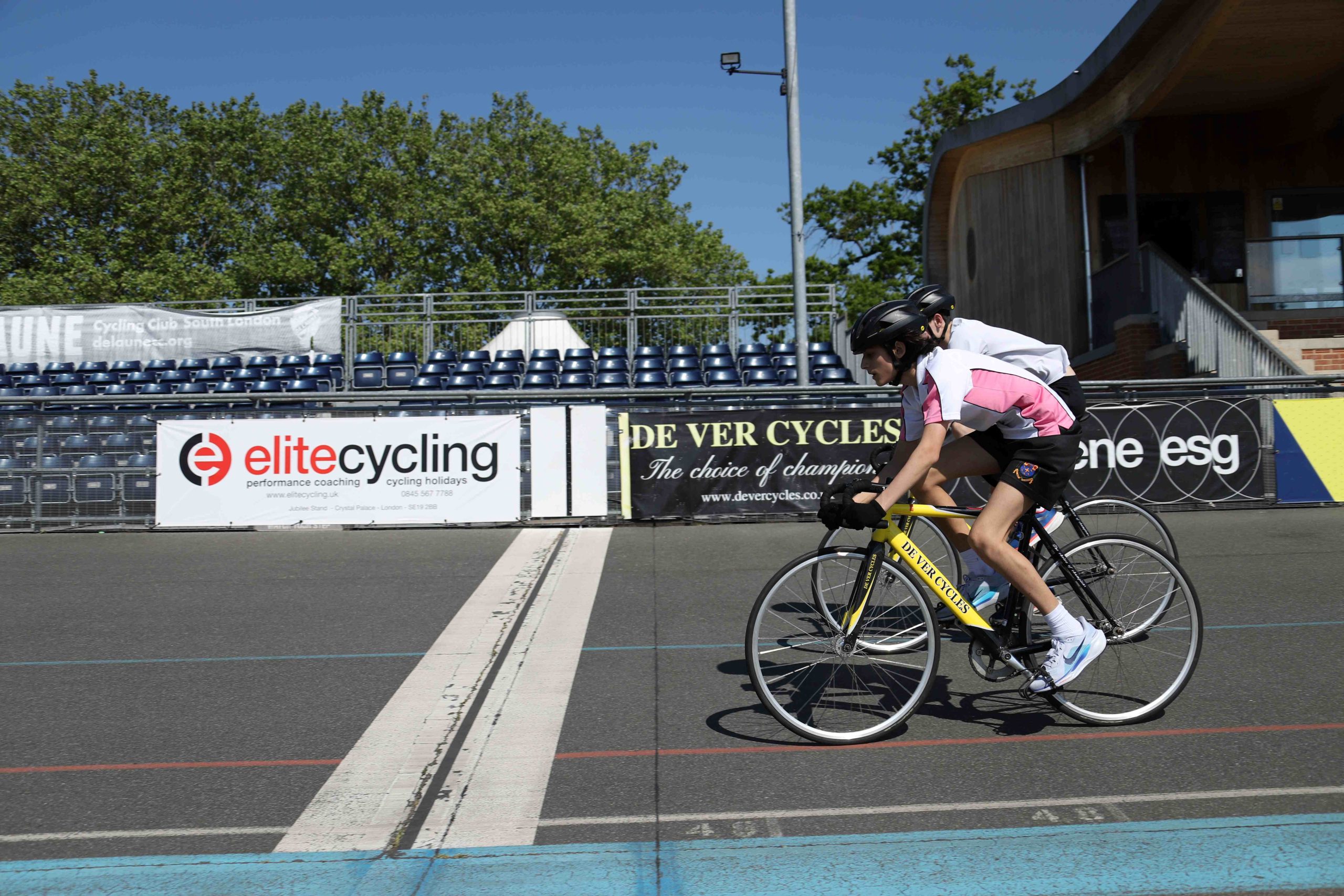 Two boys on their bikes just about to cross the finish line together at the Herne Hill Velodrome