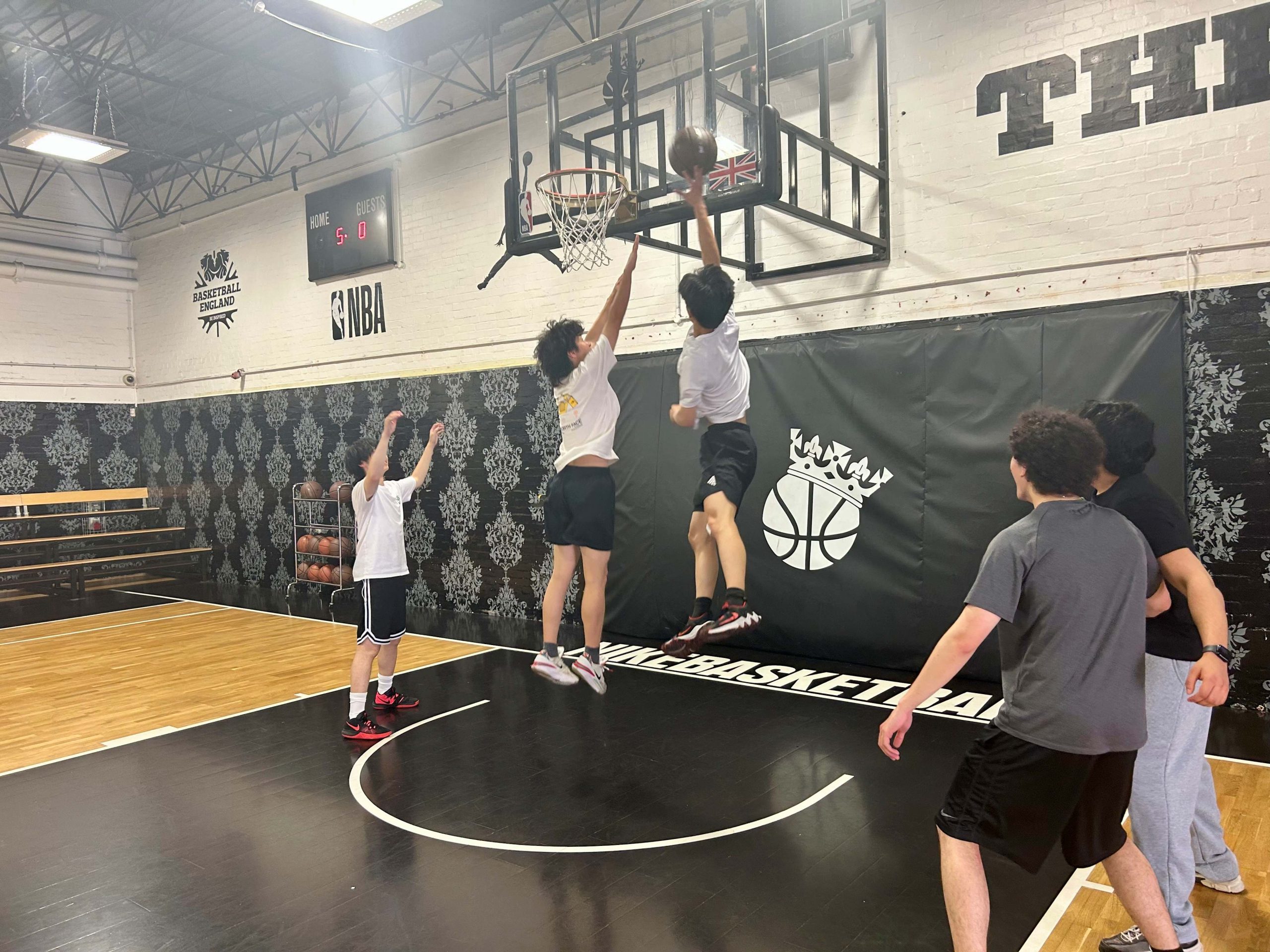 Two boys jumping in the air, one about to score a goal