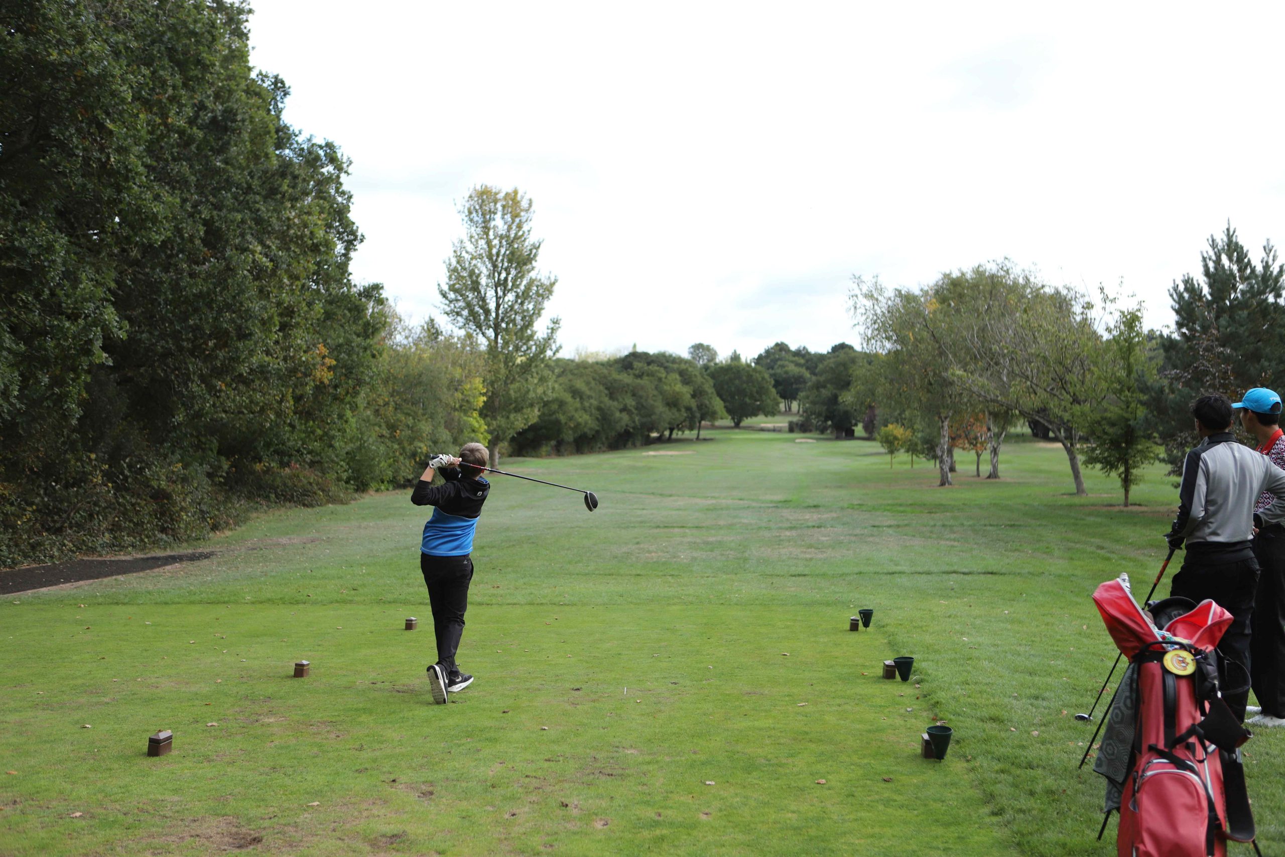 Boy just finished his hit on the golf course