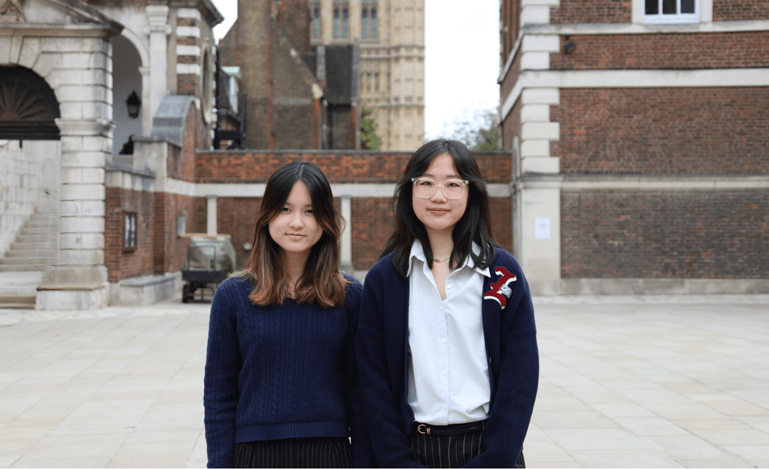 Essay winning pupils, Genevieve and Lillie, stand in Little Dean's Yard