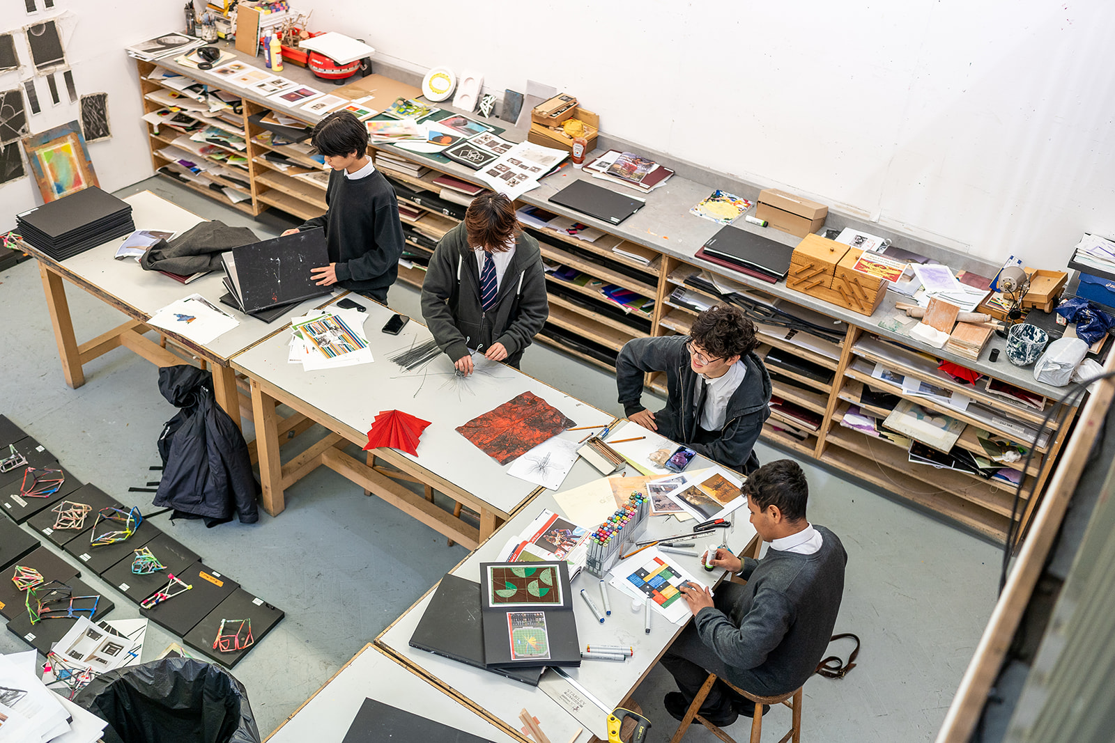 Looking down at four boys who are sitting at a long table in Art