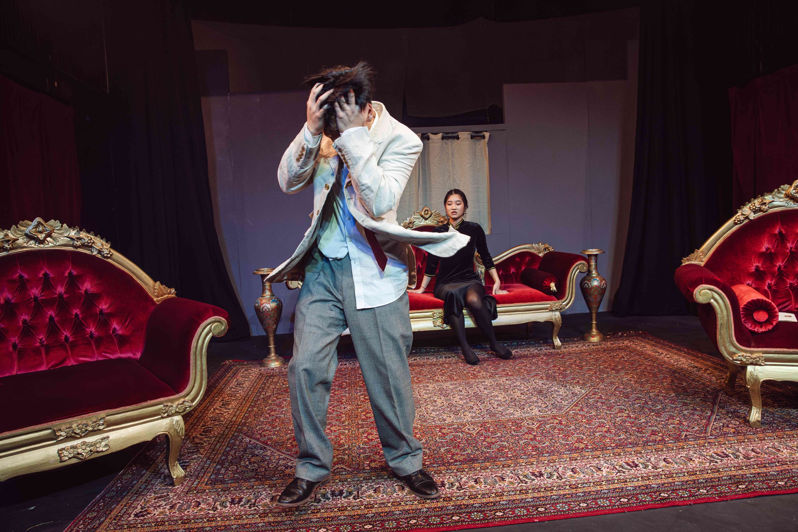 A boy acting distressed on stage with a girl