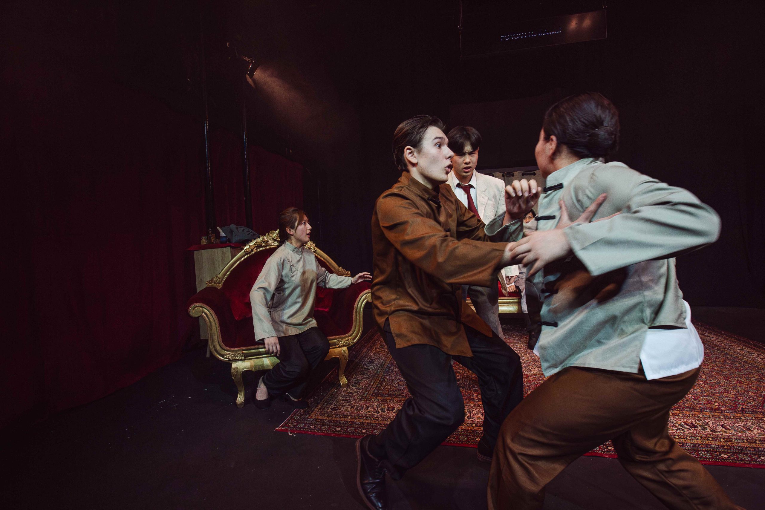 Four actors in a brawl on stage