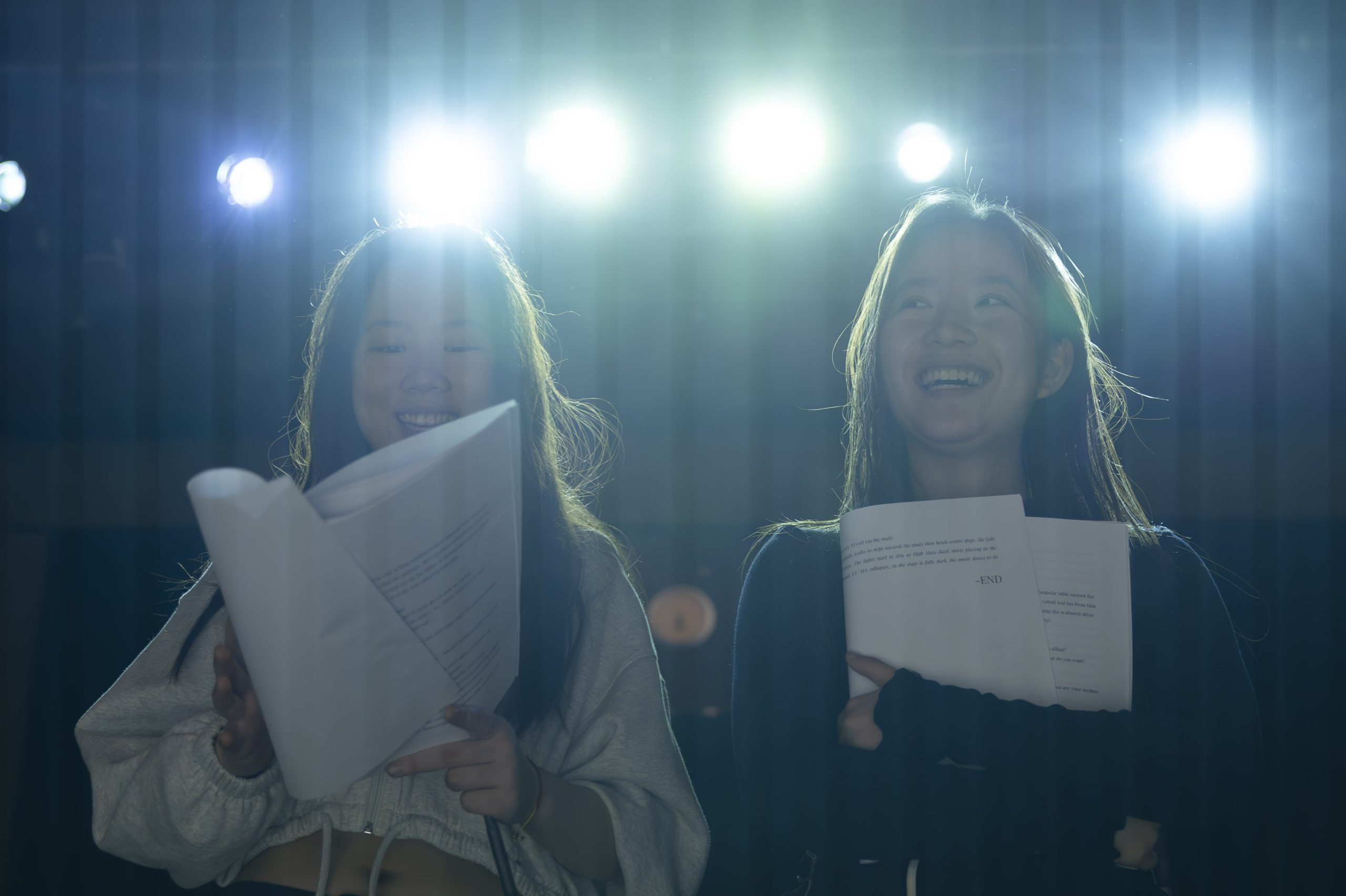 Two girls, the director and Dramaturg standing with scripts in hand