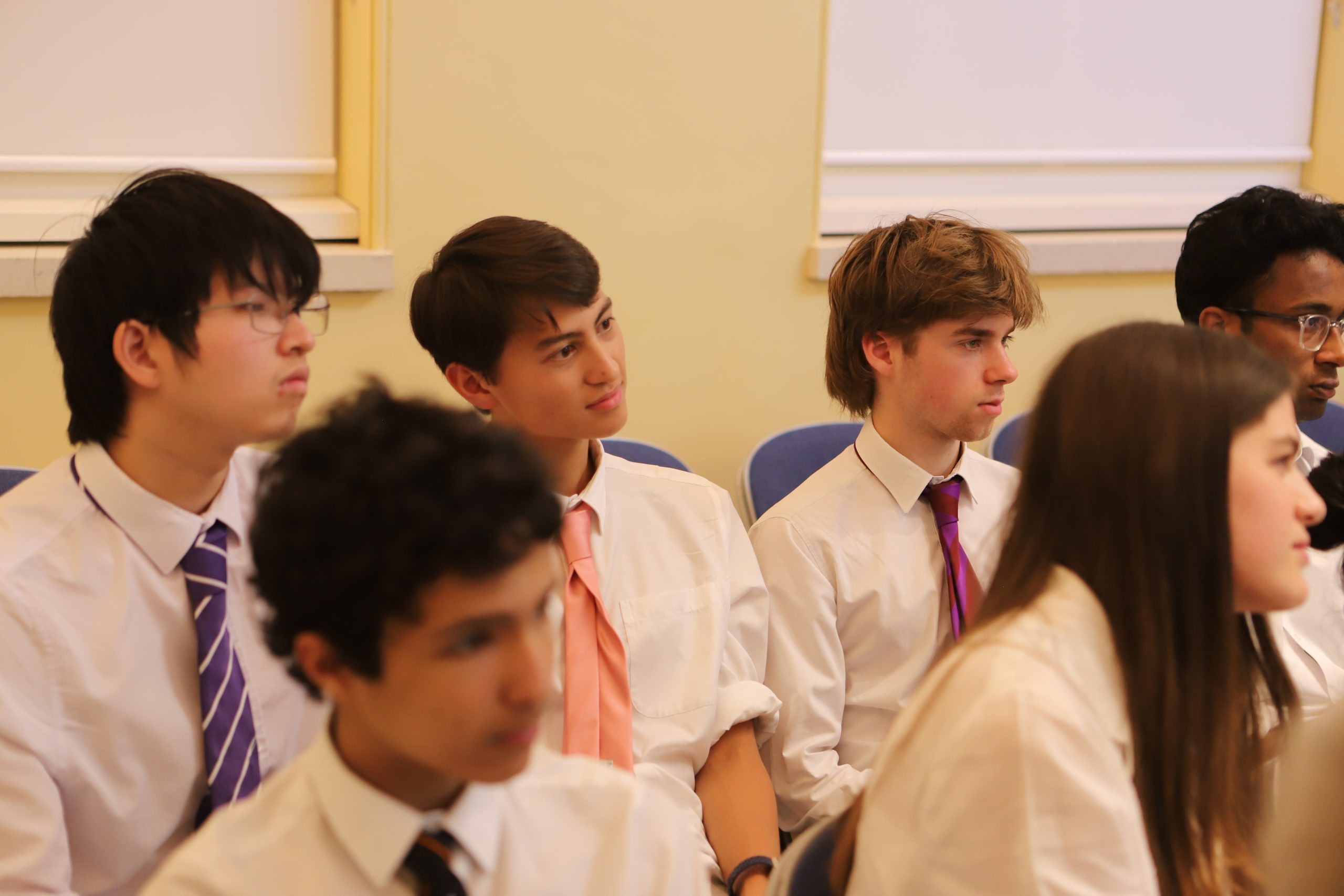Four male pupils watching the talk, one smiling in the middle.
