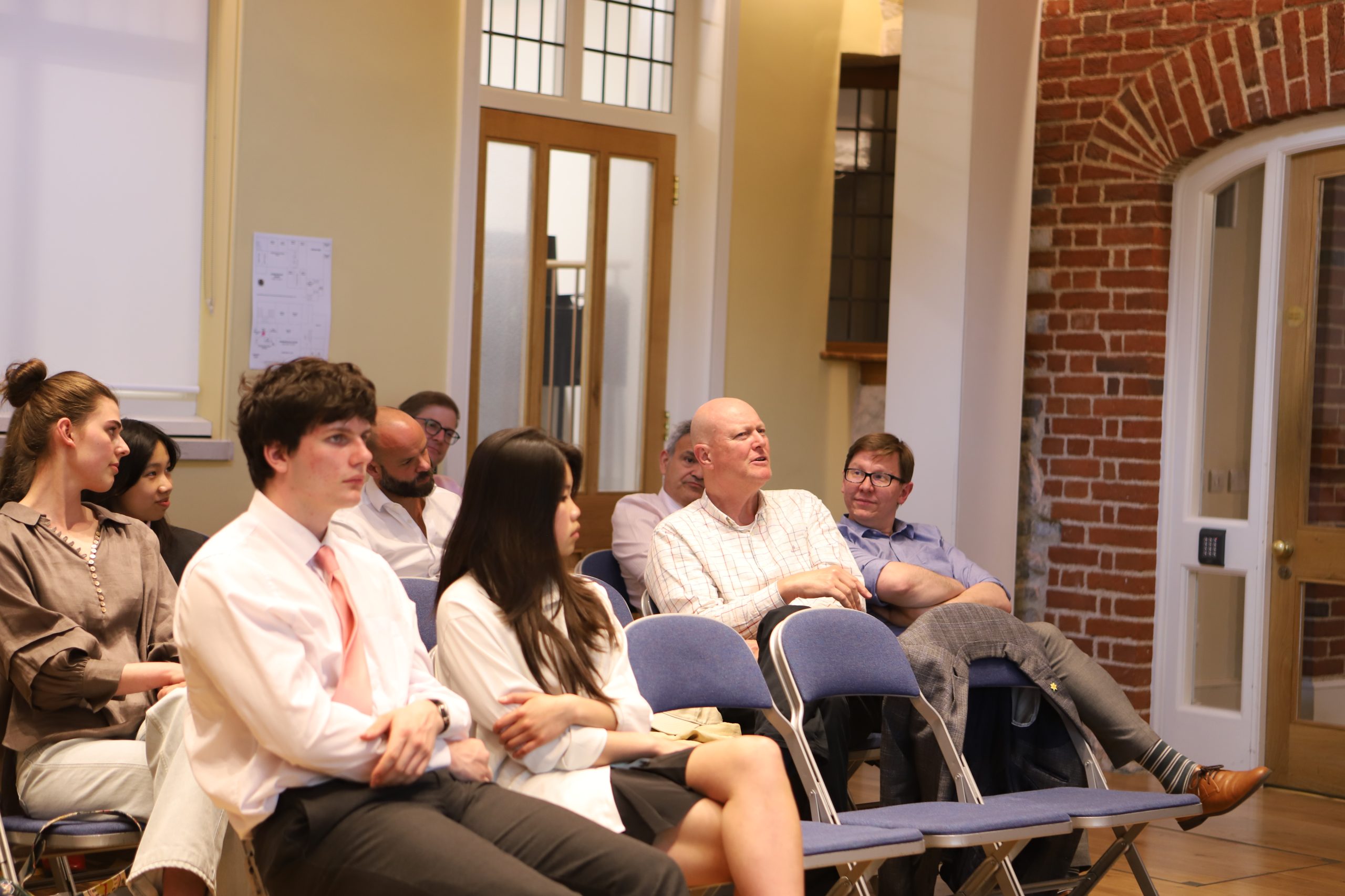 Pupils and audience members, male and female, with an older man asking a question