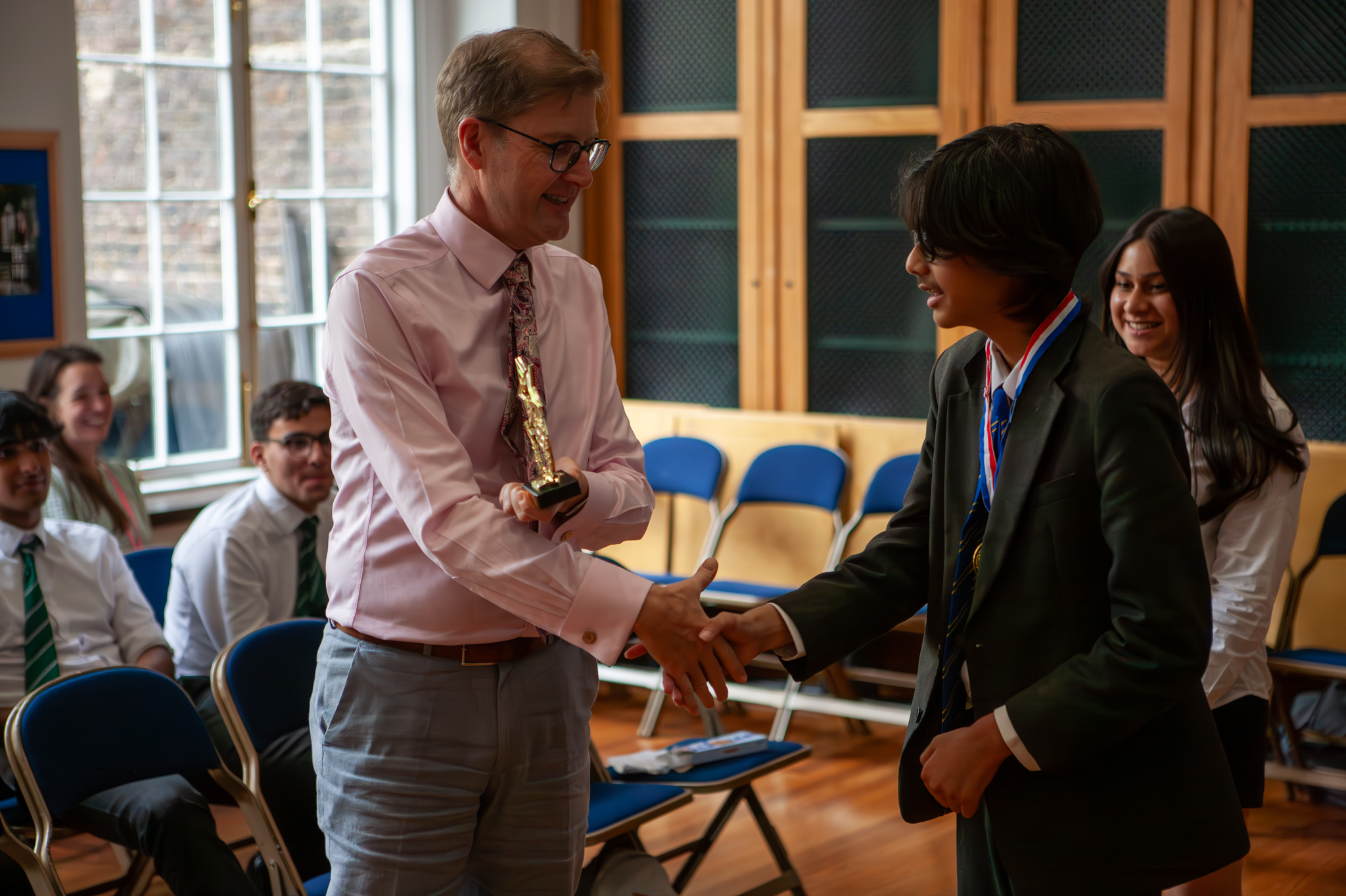 The Head Master award the winner their trophy at the front of the audience