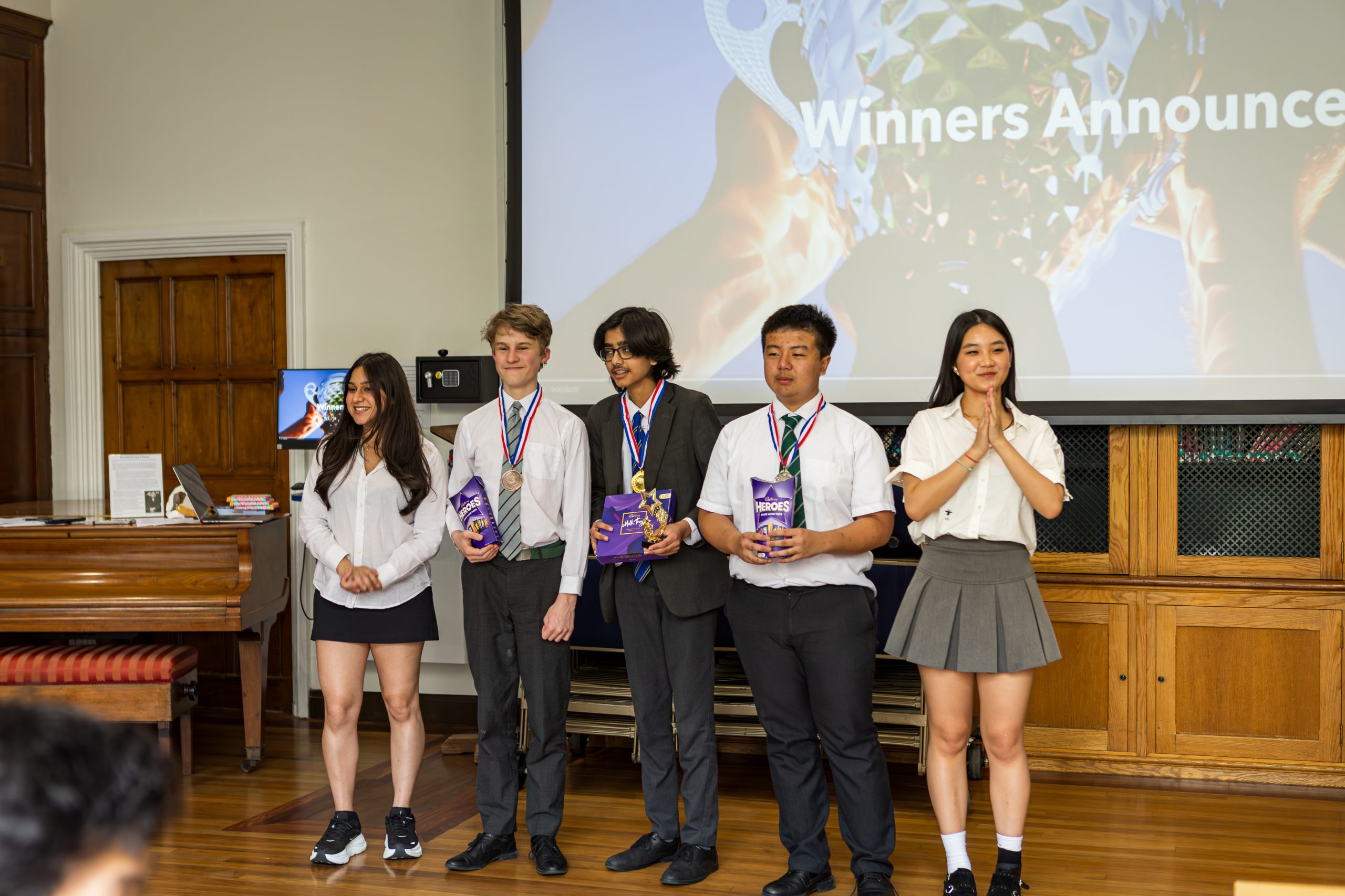 The winner and first and second runner-up standing at the front with their medals on, with the organisers either side