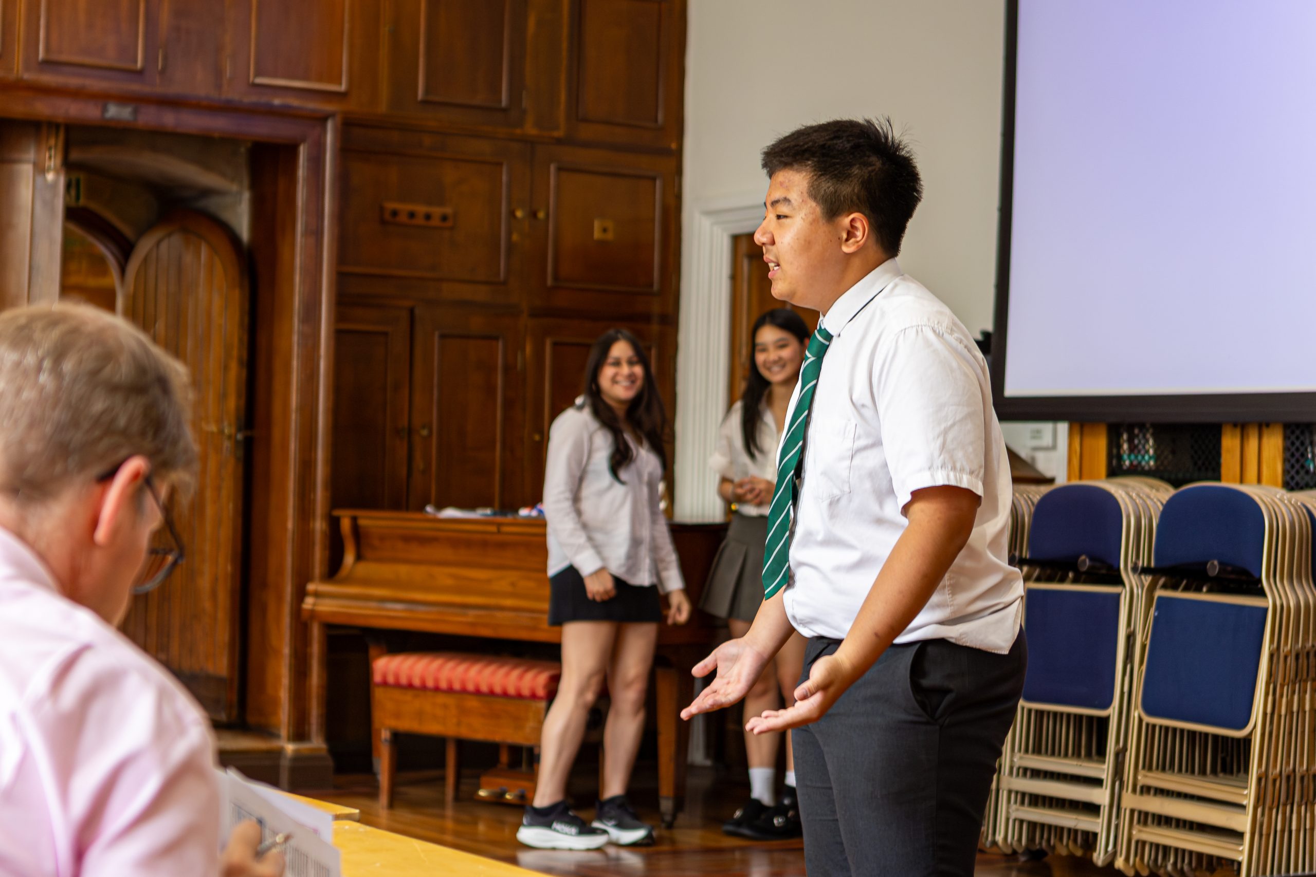 One speaker in front of the audience with the two organisers in the background