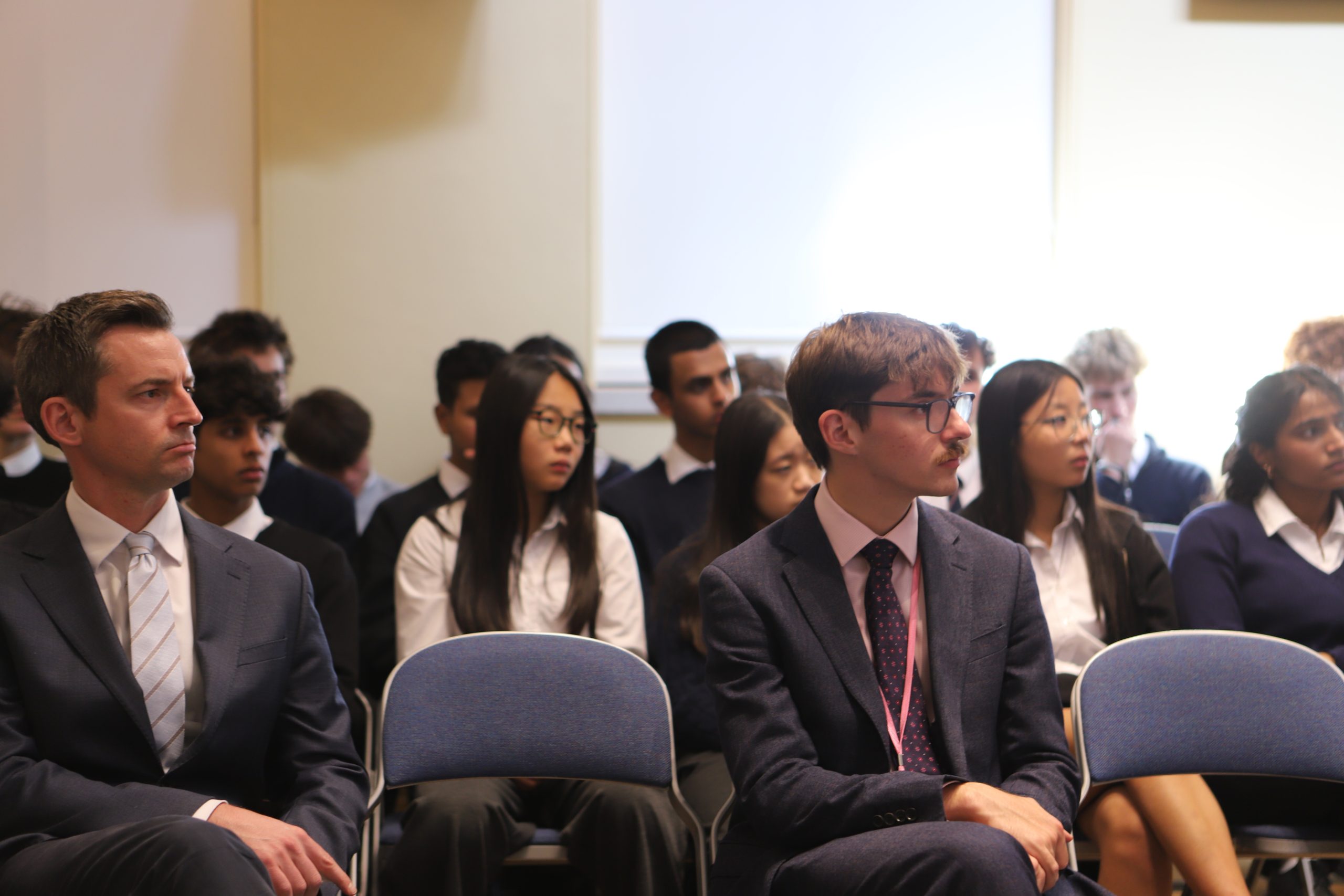 A thoughtful audience of boys and girls, with two teachers on the front row