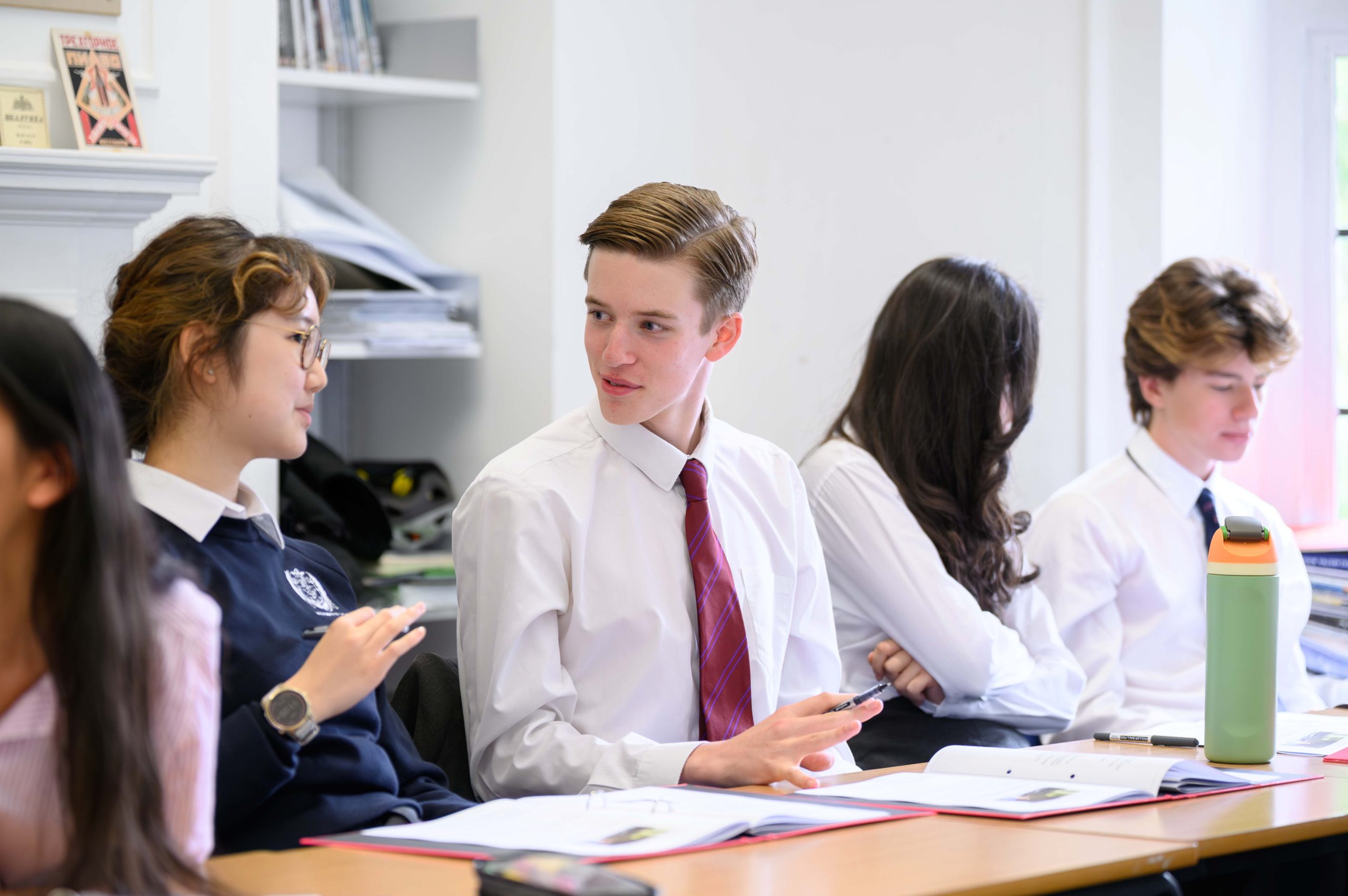 Two pairs, a boy and a girl in each, discussing content in a Wellbeing class