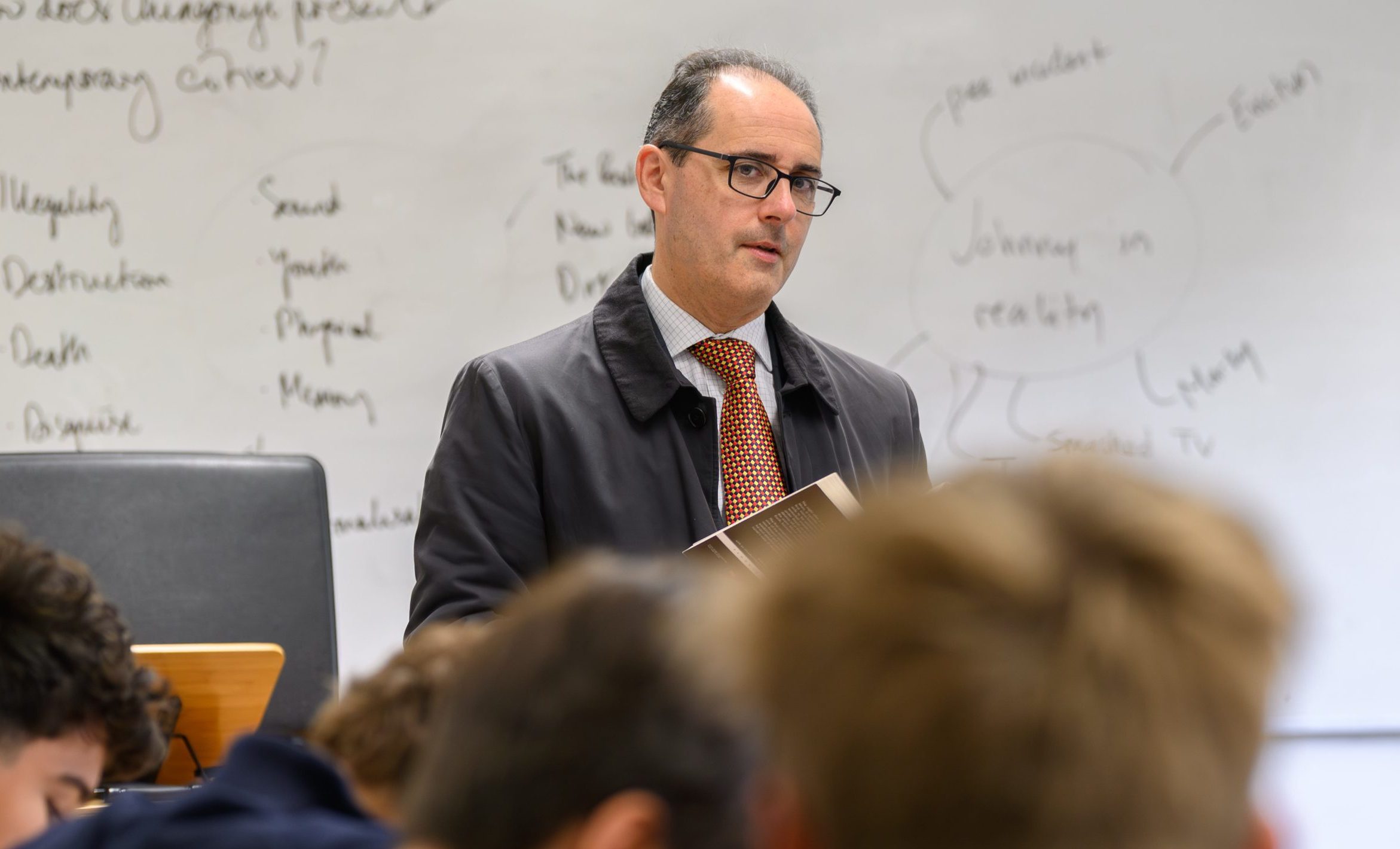 An English teacher stood up in front of his class with an open book