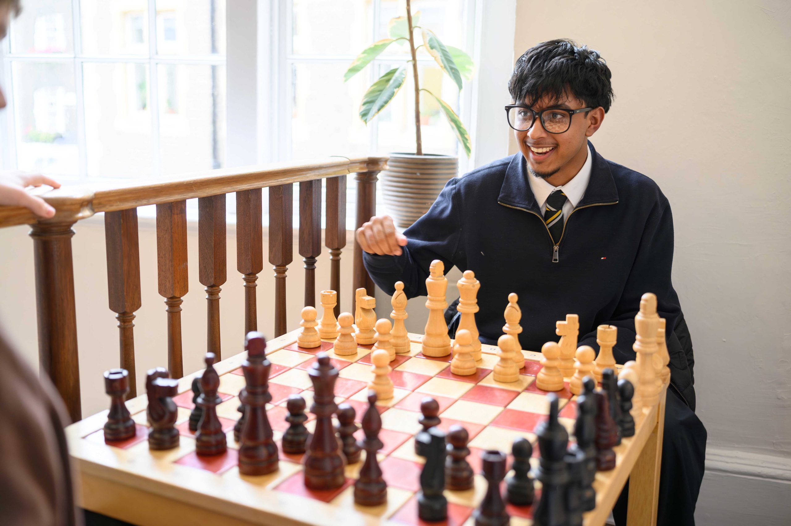 A boy playing chess, smiling