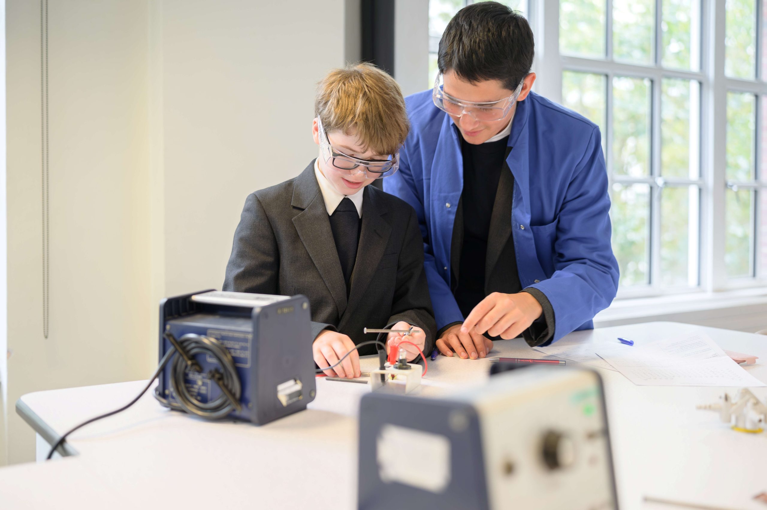 Two Year 9 boys smiling while doing a Chemistry practical together