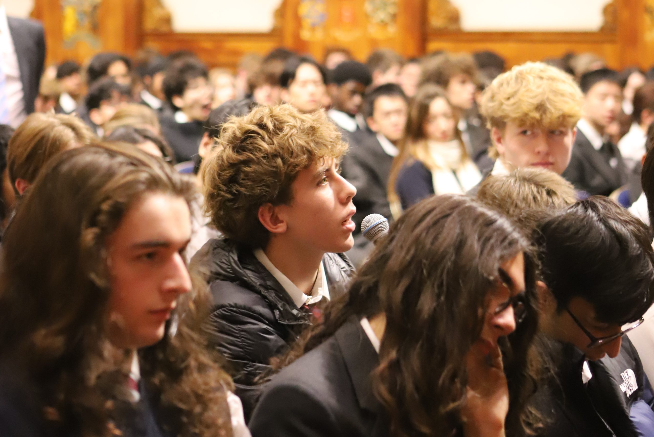 A boy in the audience of Basi's Locke Lecture, asking him a question on the microphone