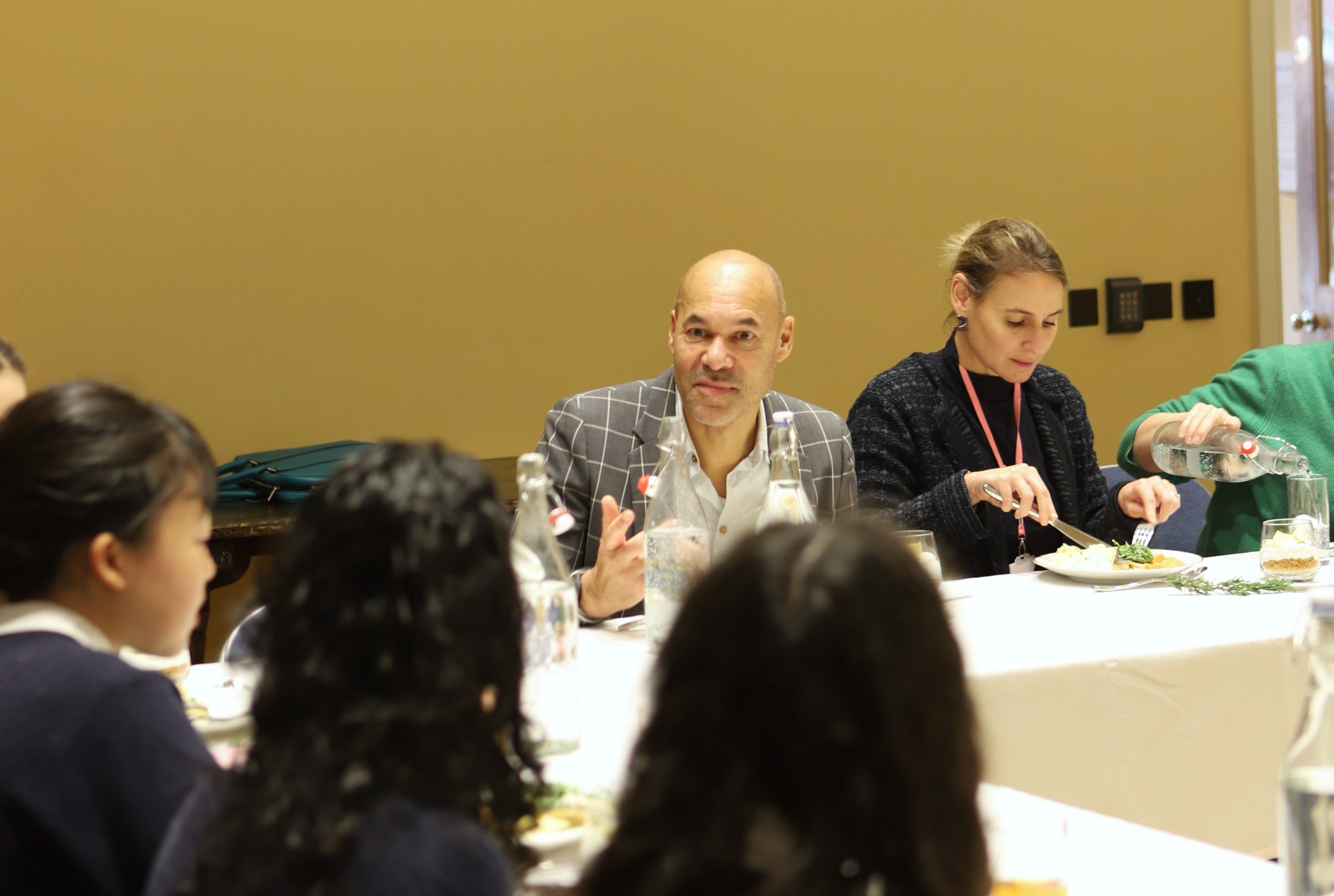 Basi speaking to four girls at the communal table in the Locke lunch