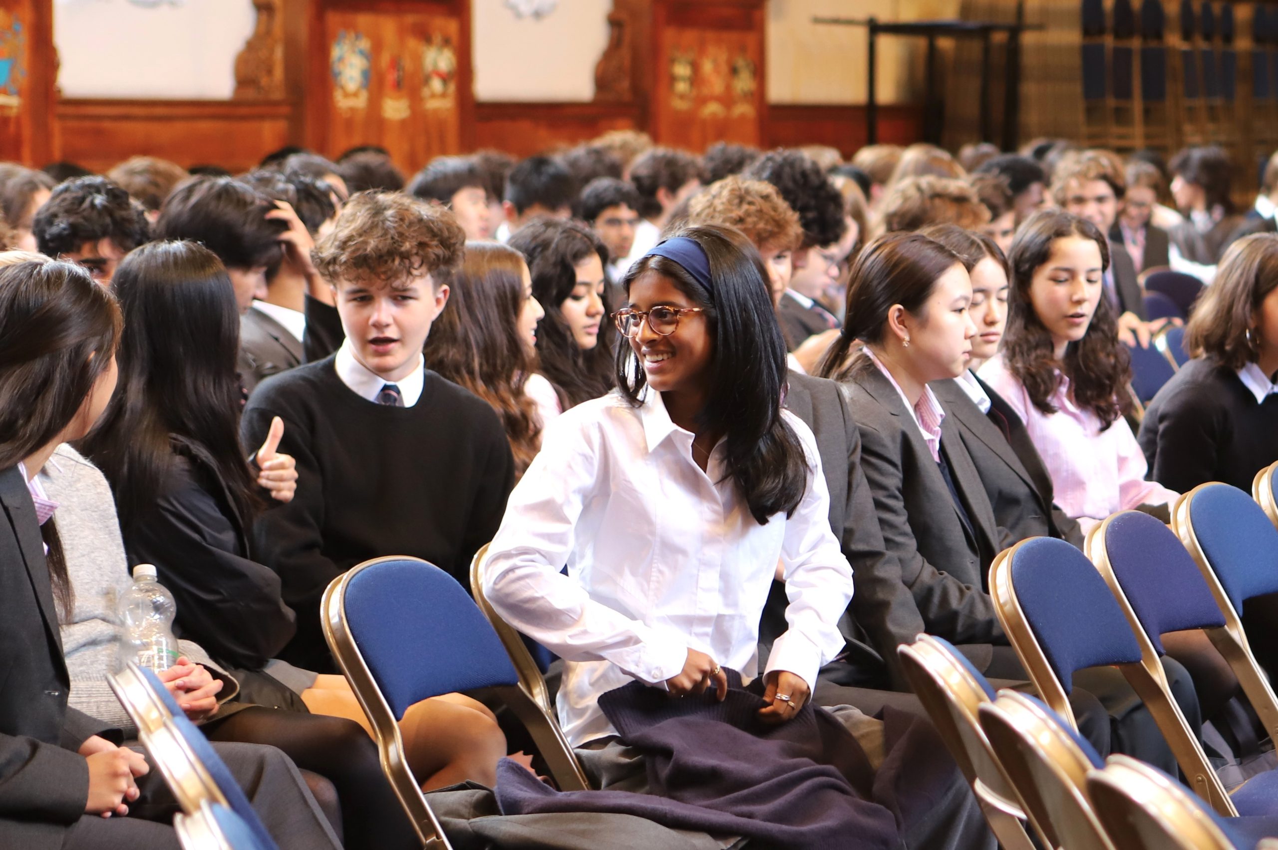 Group of Sixth Form pupils chatting in the audience of a Locke Lecture, before the start.