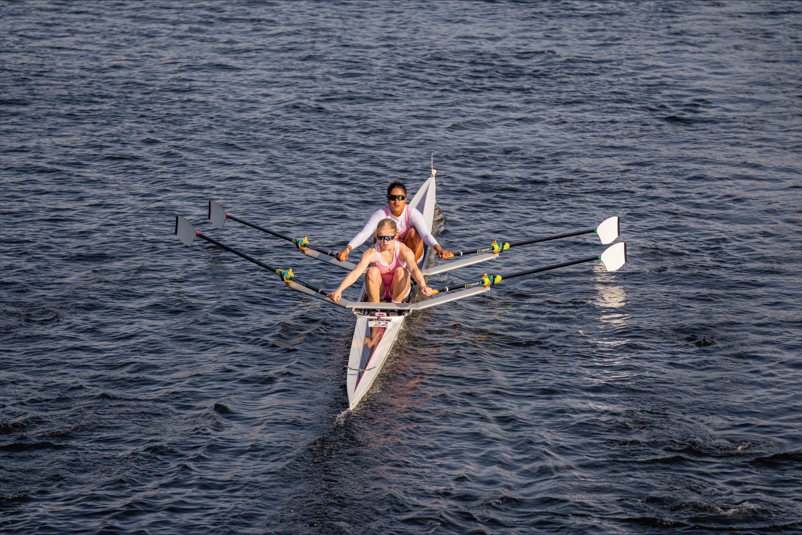 Two girls rowing together in a boat