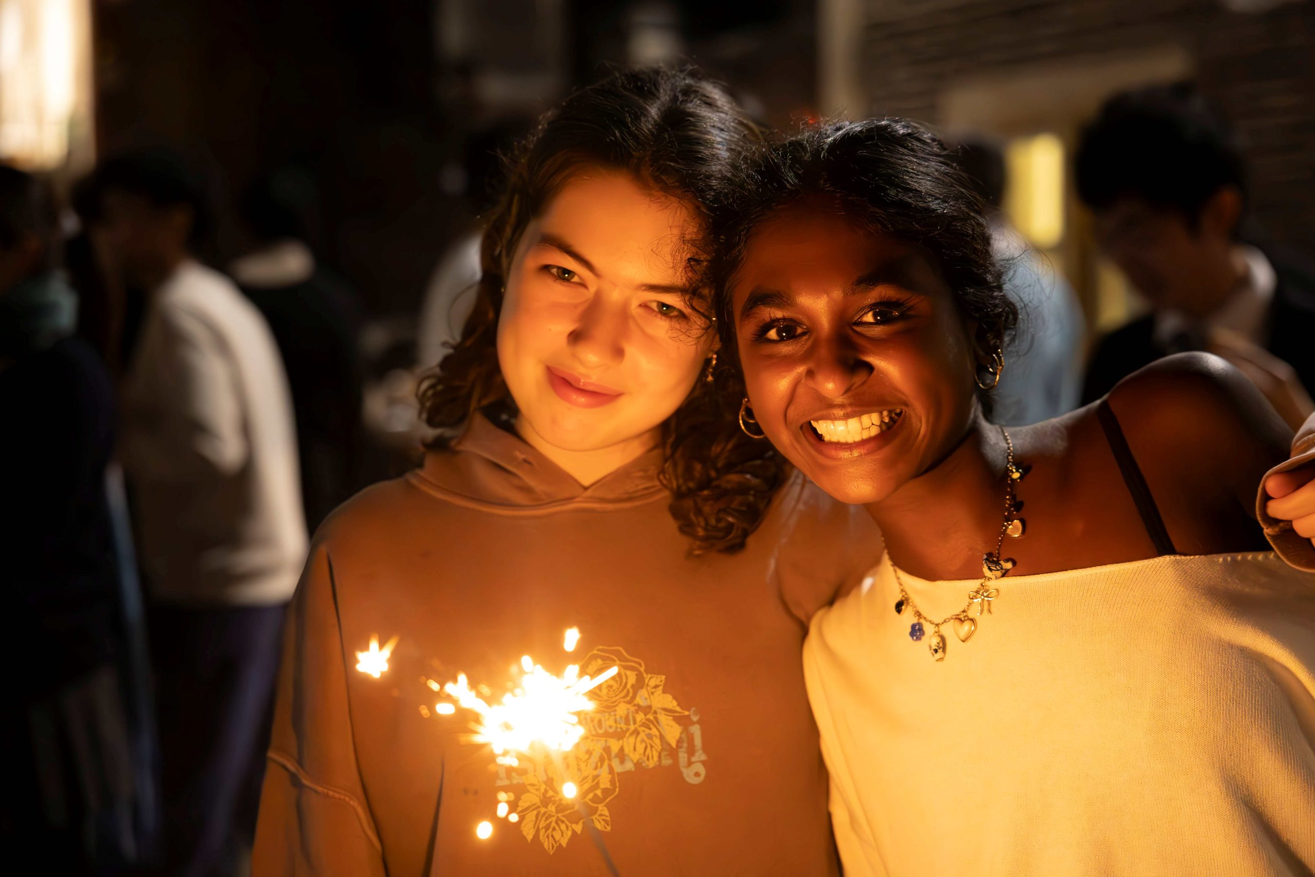 Two girls with sparklers smiling at the camera