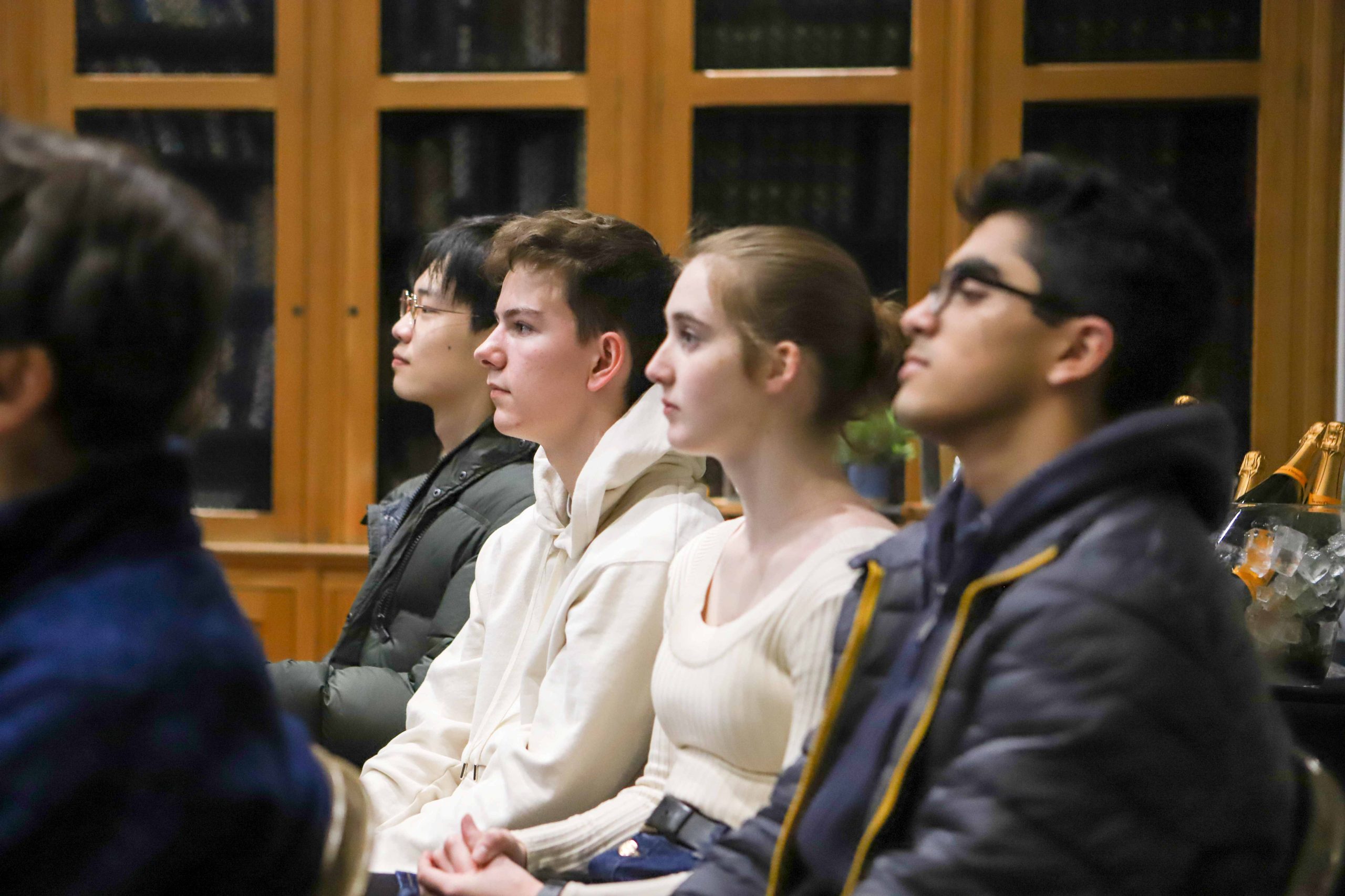 Three boys and one girl in the audience listening to Professor Lockwood