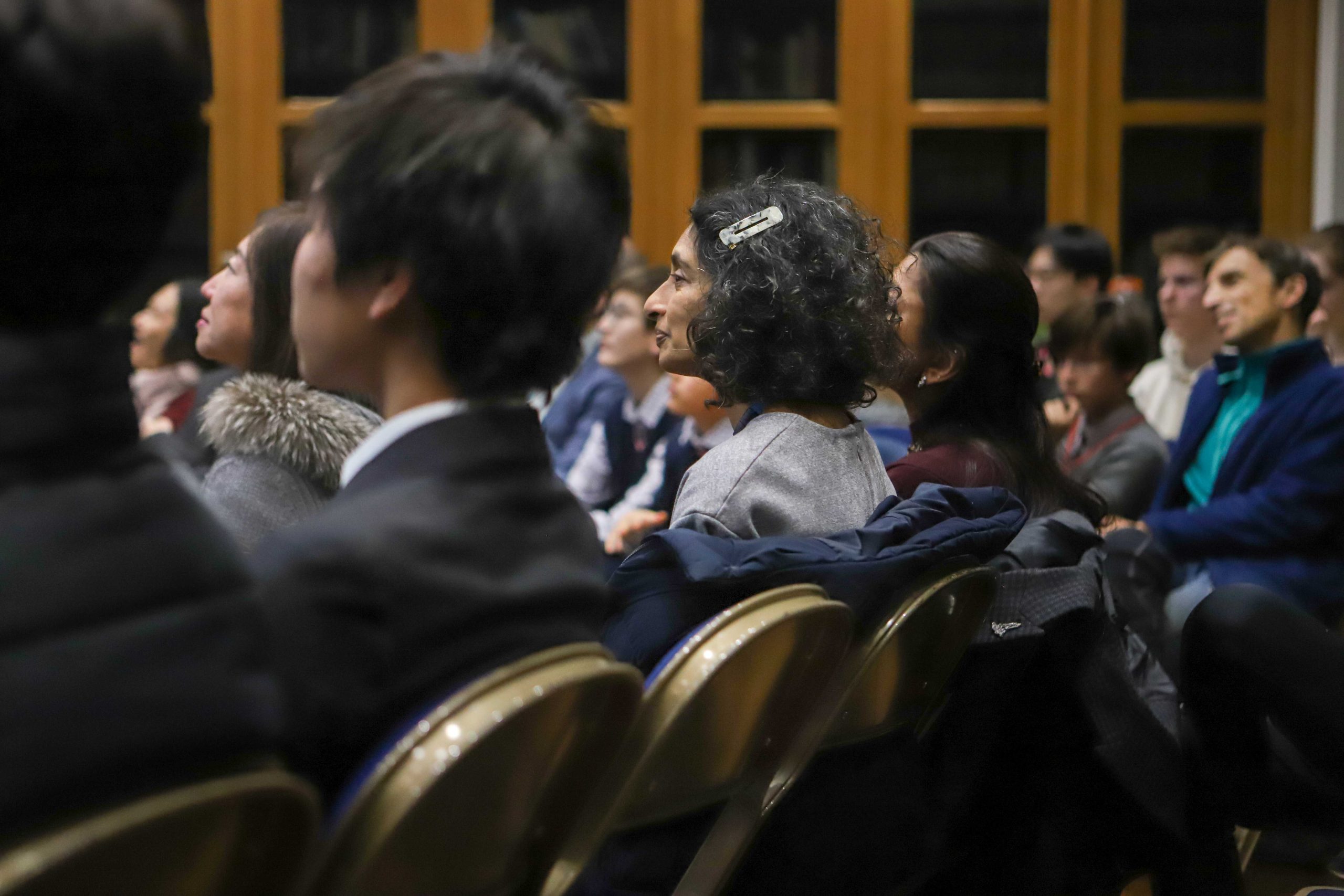 A parent in the audience, listening to the talk by Professor Lockwood and smiling