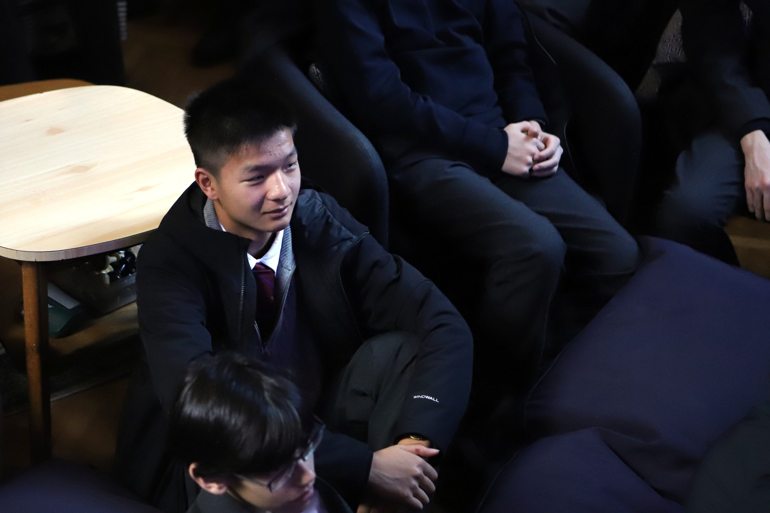 A pupil smiling, sat watching the talk.