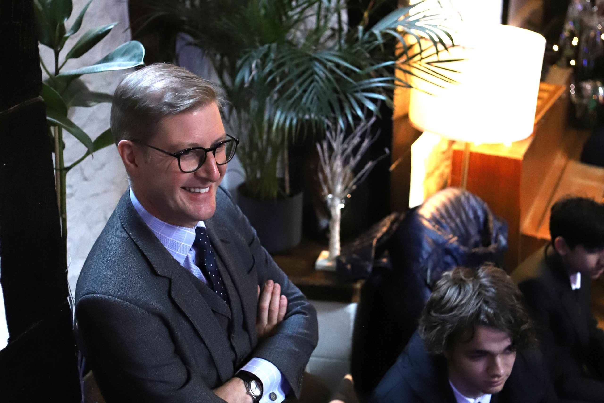 The head Master standing watching the talk, smiling