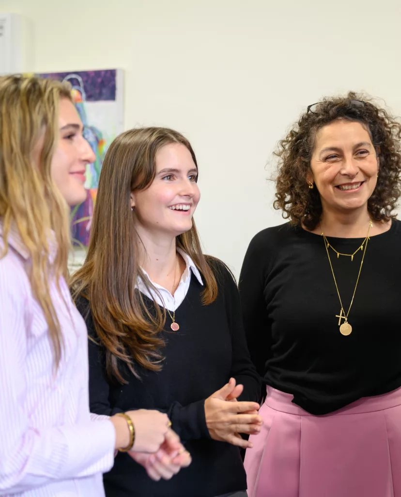 Two girls smiling in uniform with Ashburnham's housemaster