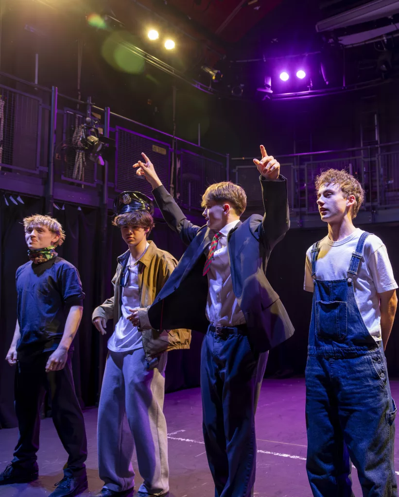 Four boys in costume on stage for their curtain call in the MFH