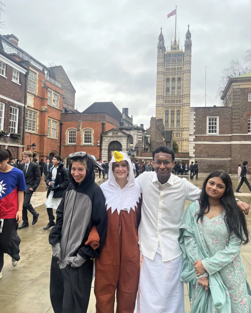 Four pupils dressed up in Little Dean's Yard, with the Victoria Tower inn the background, for cultural dress day: an eagle, Indian dress and one unidentifiable animal costume.
