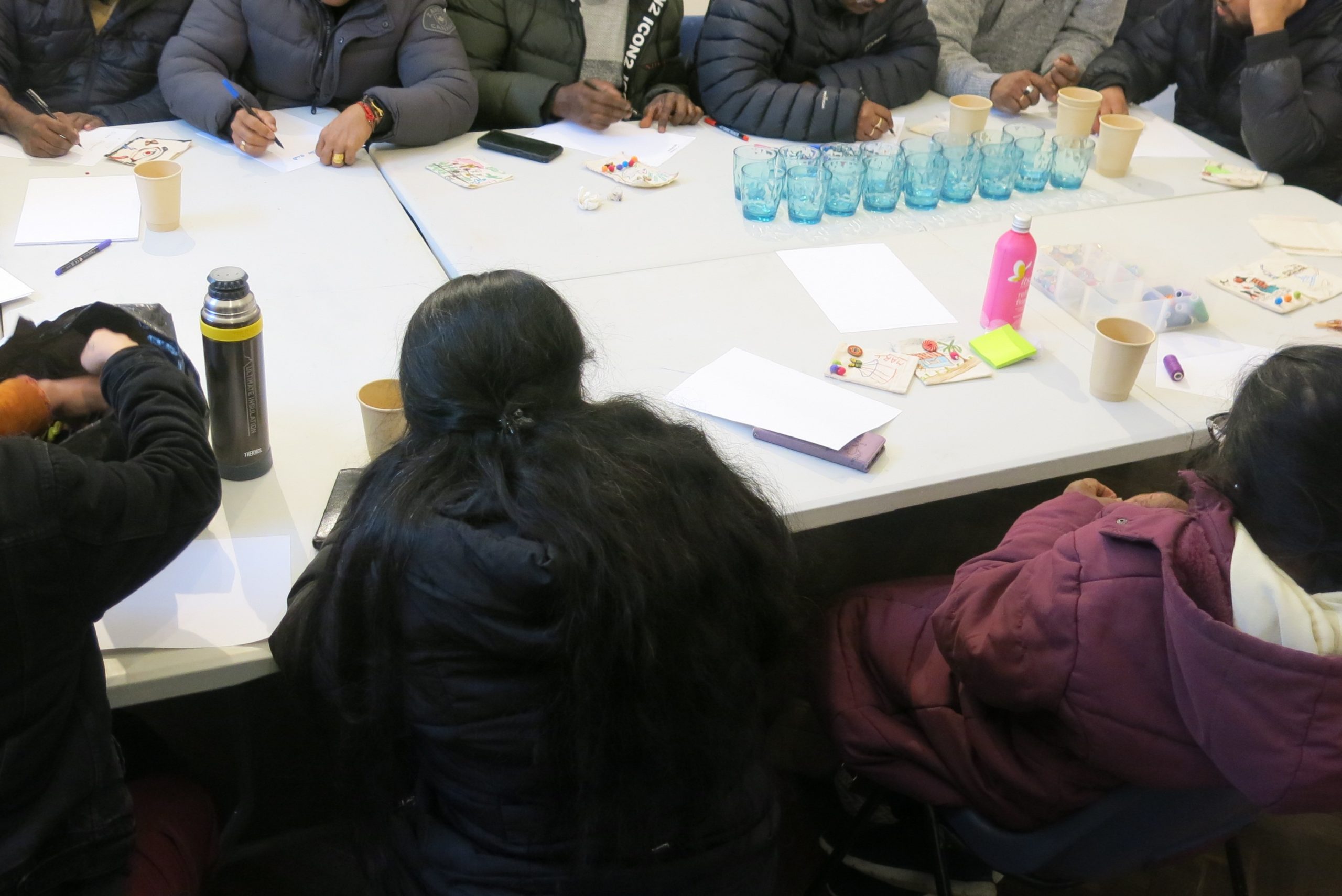 Attendees sitting around a table talking and doing art